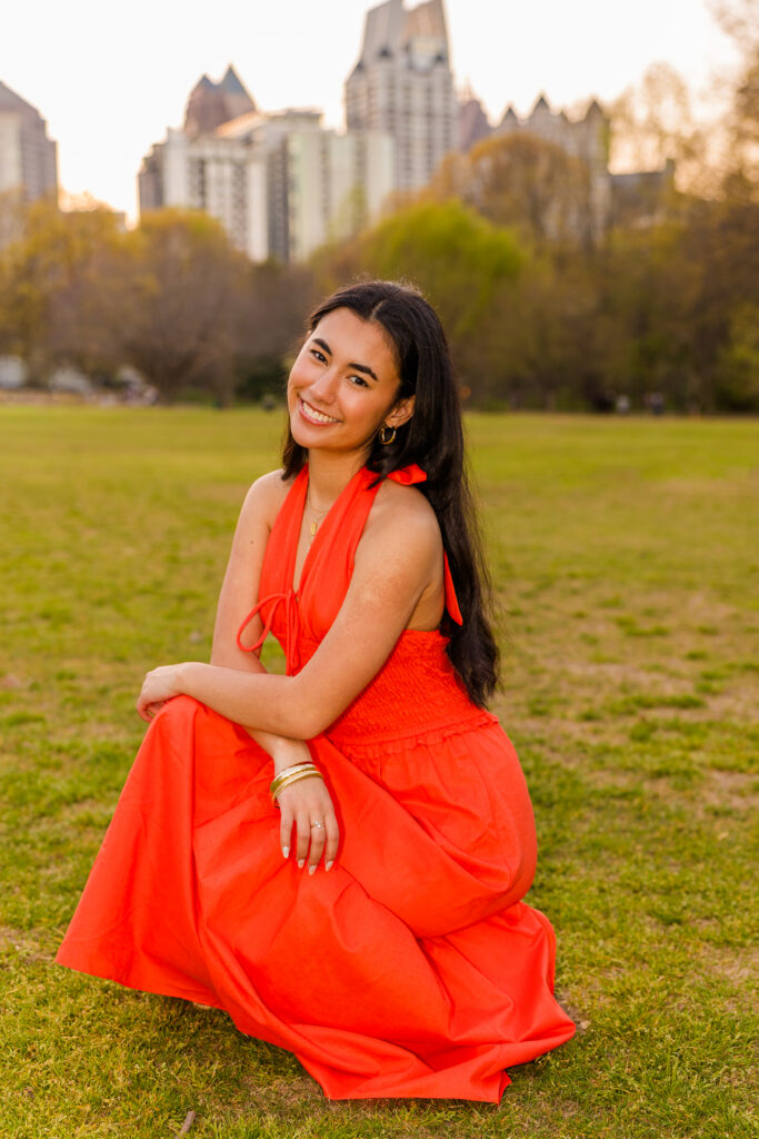 Atlanta senior photos by Laure Photography of senior squadding with Atlanta skyline in orange dress