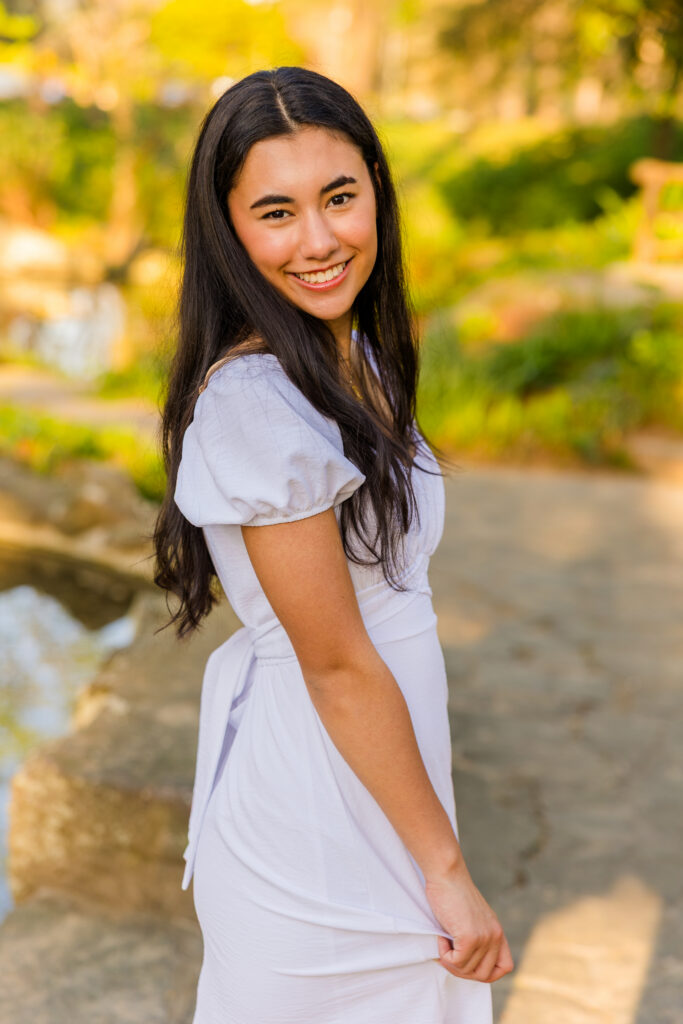 Atlanta senior photos by Laure Photography of senior twirling in white dress in park