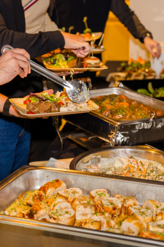 Guests serving food from buffet during corporate lunch