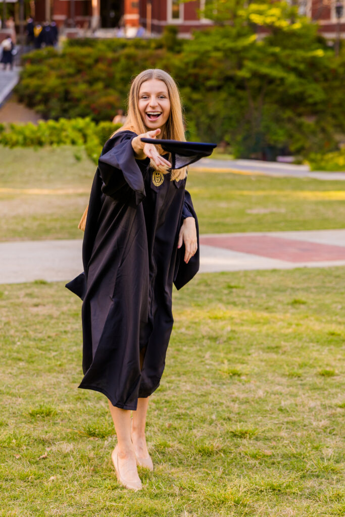 Gabriela laughing as she throws her graduation cap during Georgia Tech photos