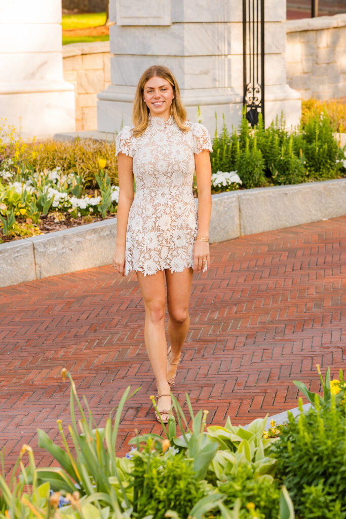 McKenzie walking toward camera in white dress during Emory graduation photos Atlanta
