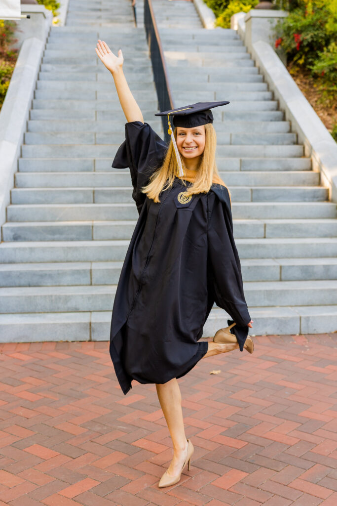 Full body graduation portrait of Gabriela celebrating on Georgia Tech stairs