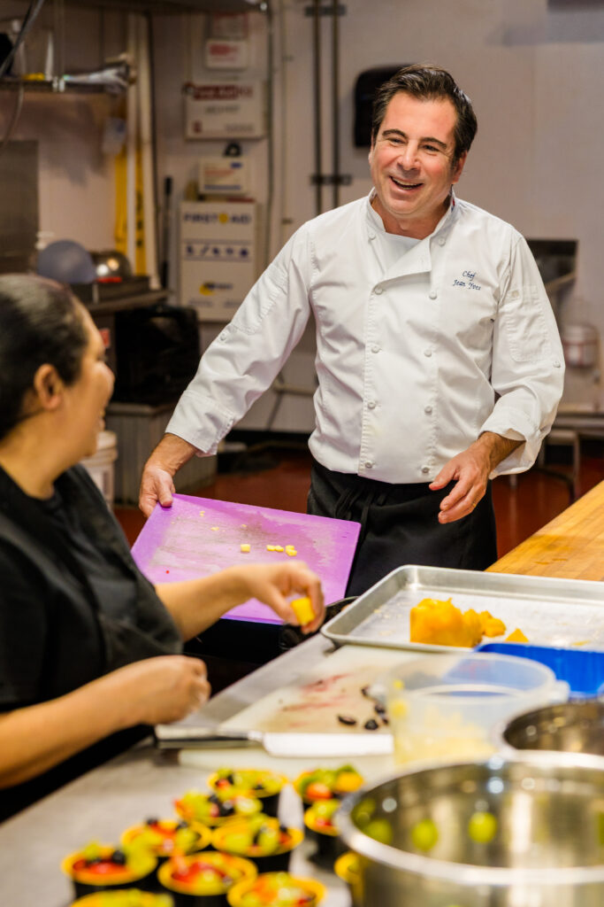 Chef laughing naturally with employee while working in kitchen