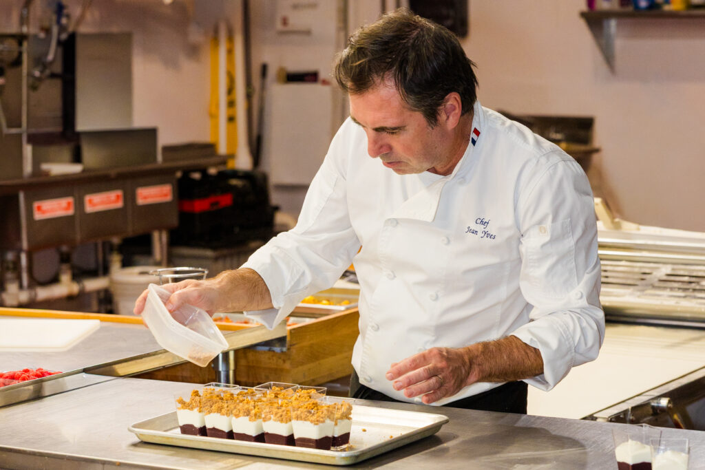 Chef adding final touches to individual desserts in kitchen