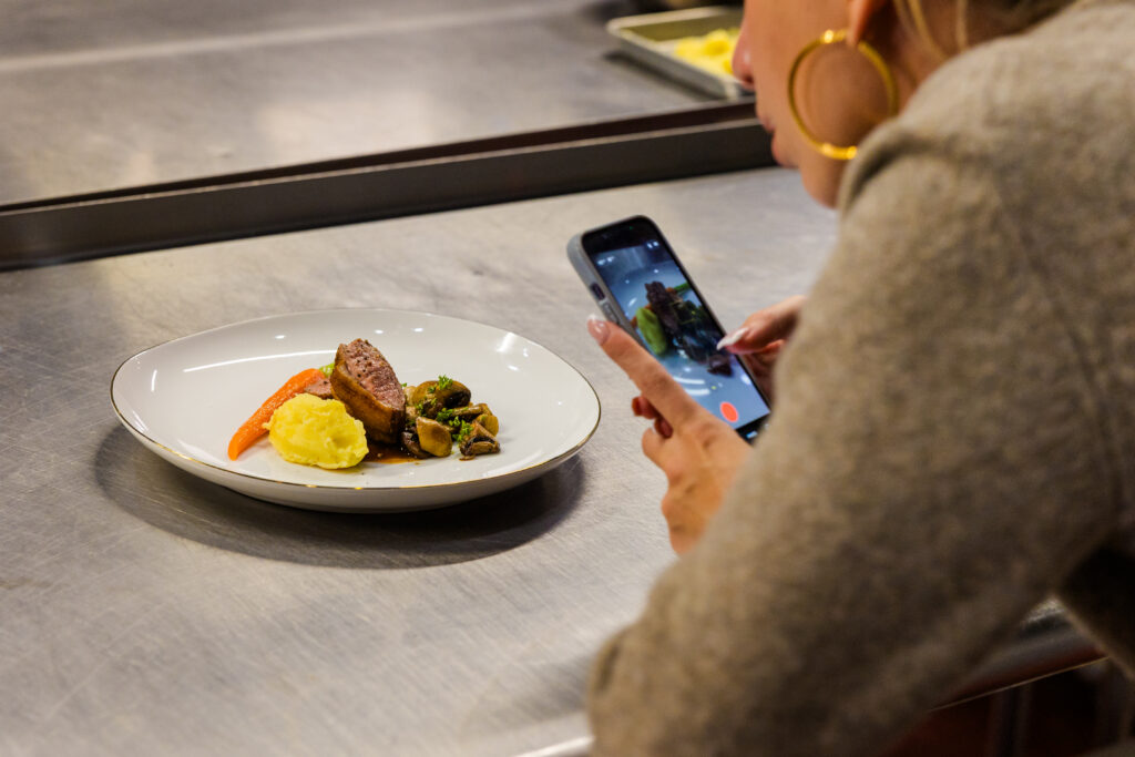 Daughter taking photo of beautifully plated dish in kitchen