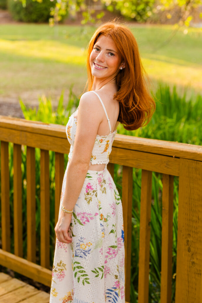 Senior girl walking on bridge looking back at camera