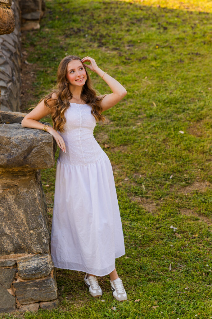 Senior posing against wall in Piedmont Park Atlanta