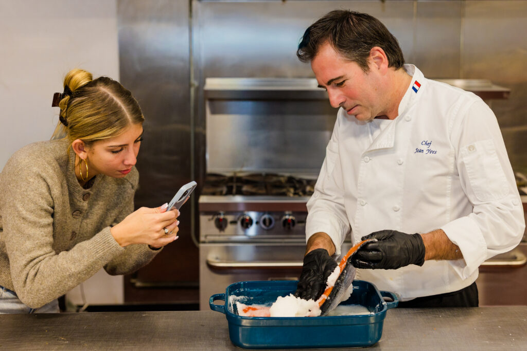 Daughter capturing chef preparing salmon dish