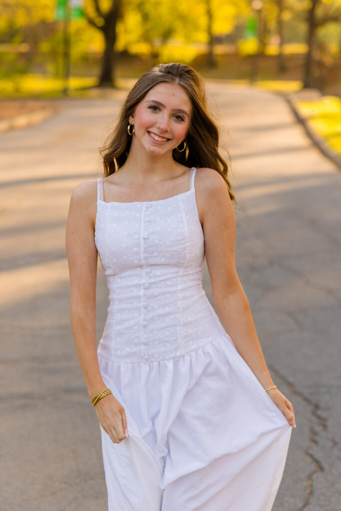 Senior playing with dress while walking in Piedmont Park