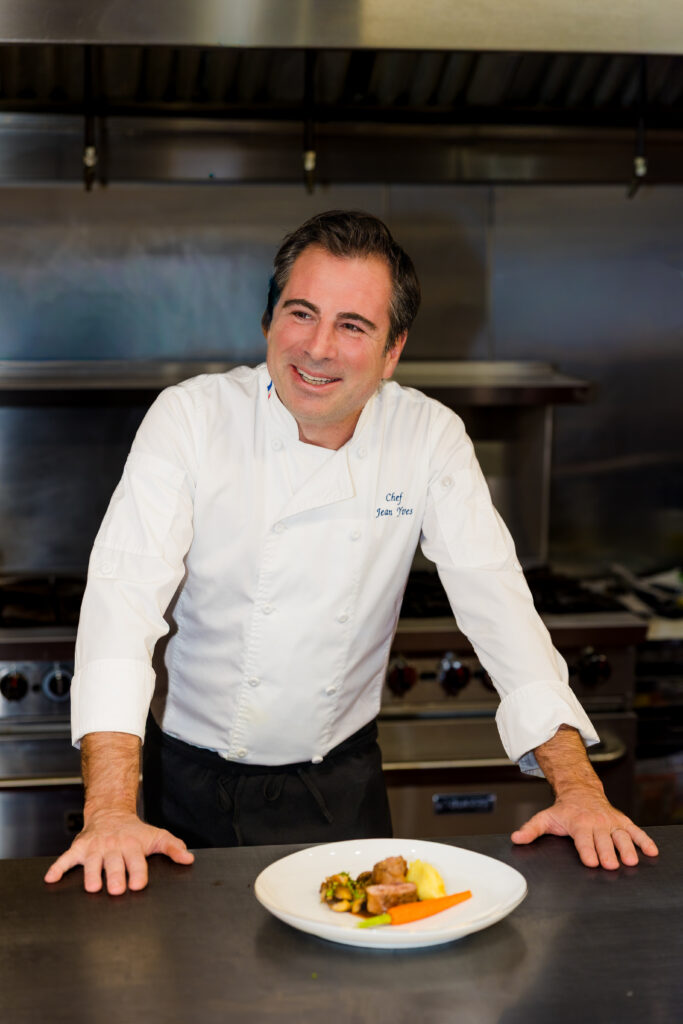 Chef standing behind plated dish looking off camera