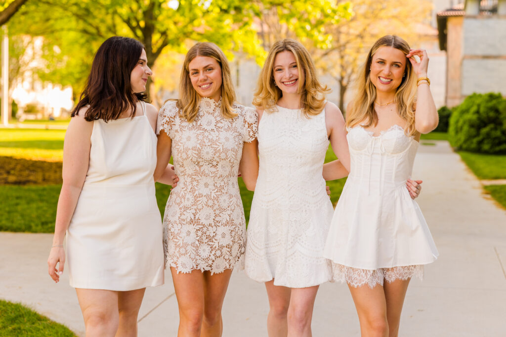 Three quarter body of girls arm in arm looking at each other