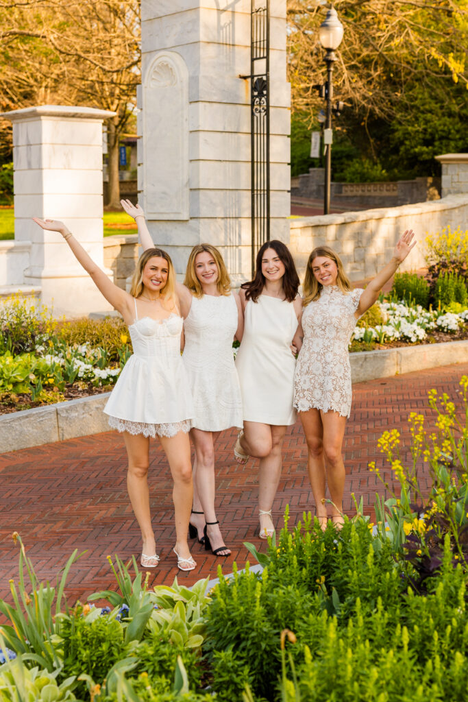 Four girls celebrating with one hand up in the air at Emory graduation session Atlanta