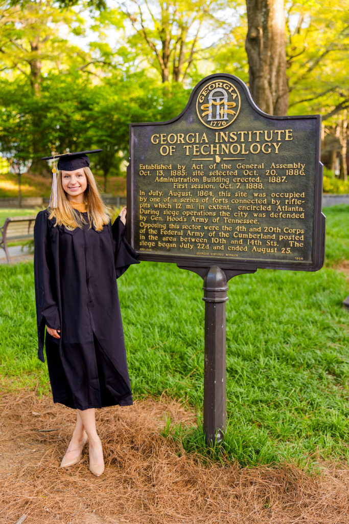 Gabriela posing in front of the Georgia Tech sign in cap and gown