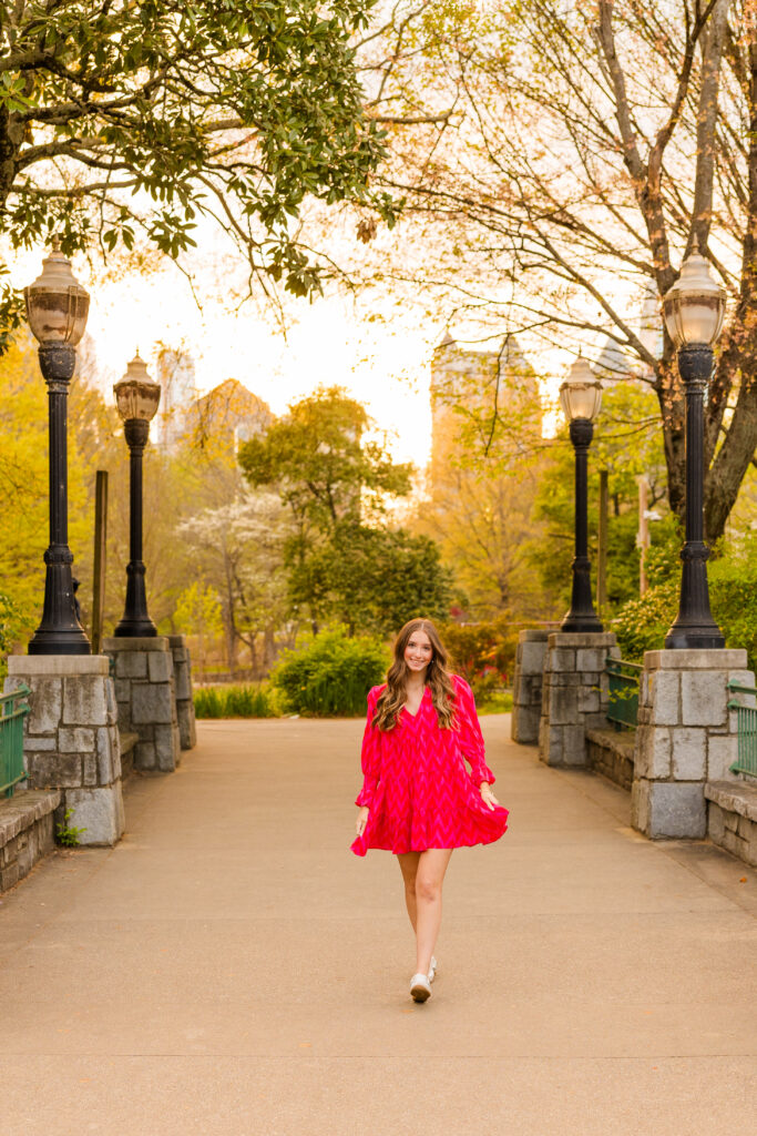 Senior playing with dress on bridge in Piedmont Park