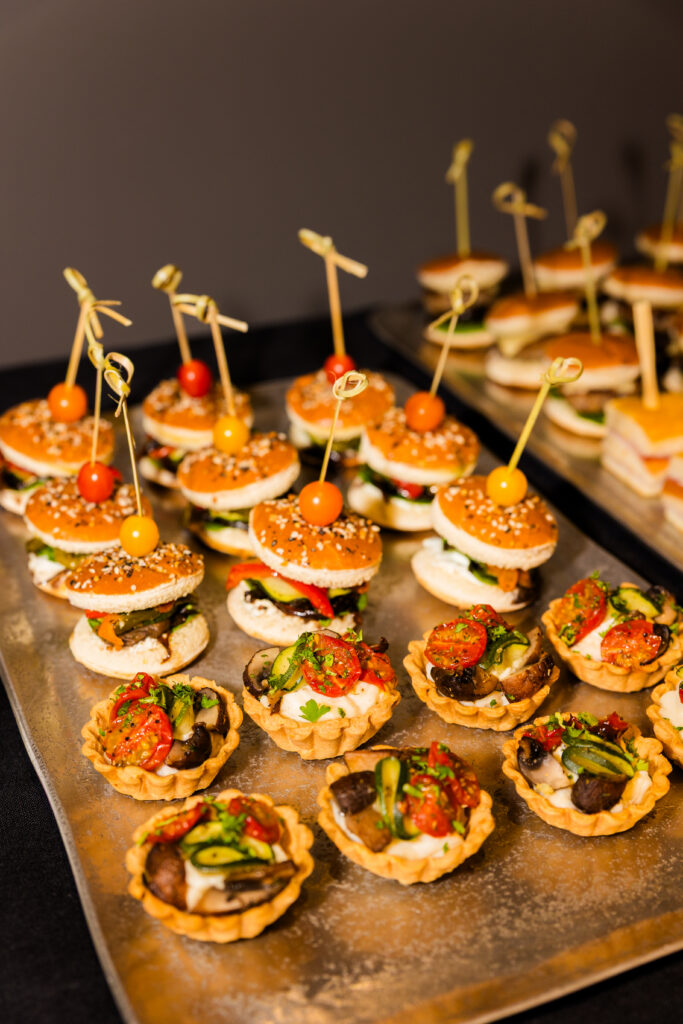Corporate buffet featuring mini burgers and vegetarian tarts