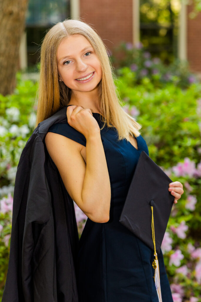 Gabriela standing holding her gown over her shoulder during Georgia Tech graduation photos