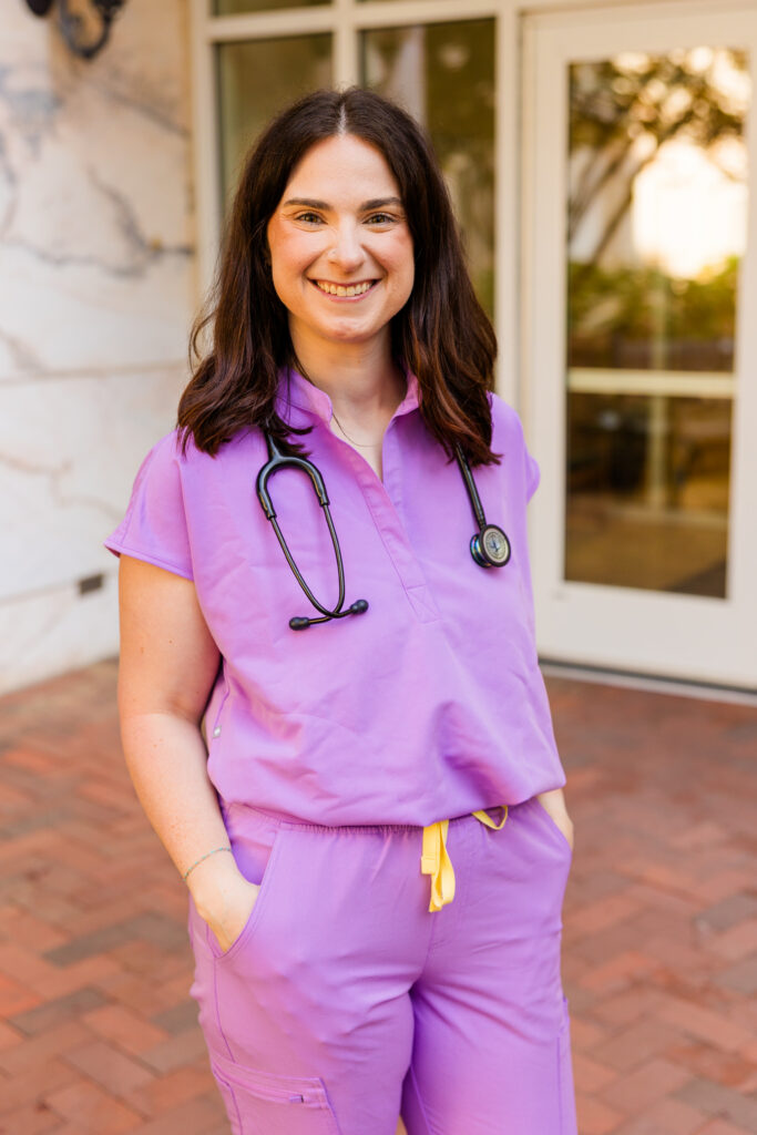 Roma in purple scrubs with stethoscope at Emory nursing graduation