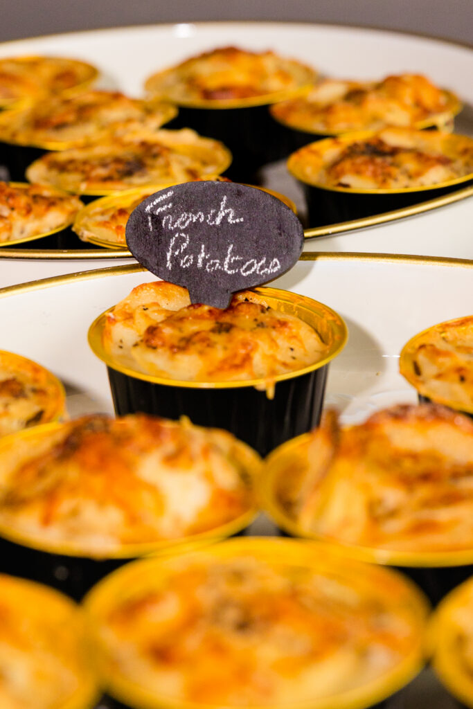 Individual potato portions with labeled sign on buffet