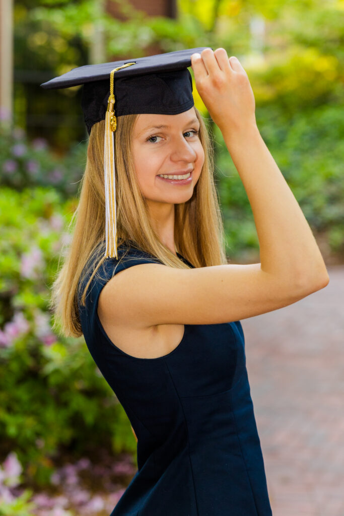Close-up portrait of Gabriela in a blue dress wearing her graduation cap at Georgia Tech