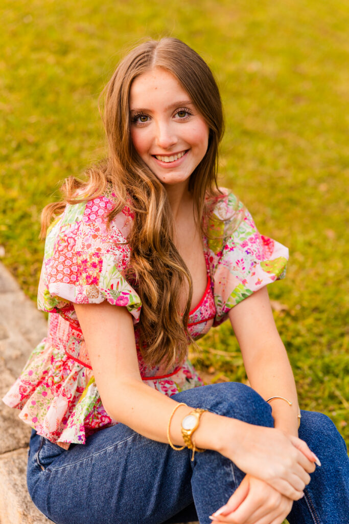 Senior sitting on stairs smiling in Piedmont Park Atlanta