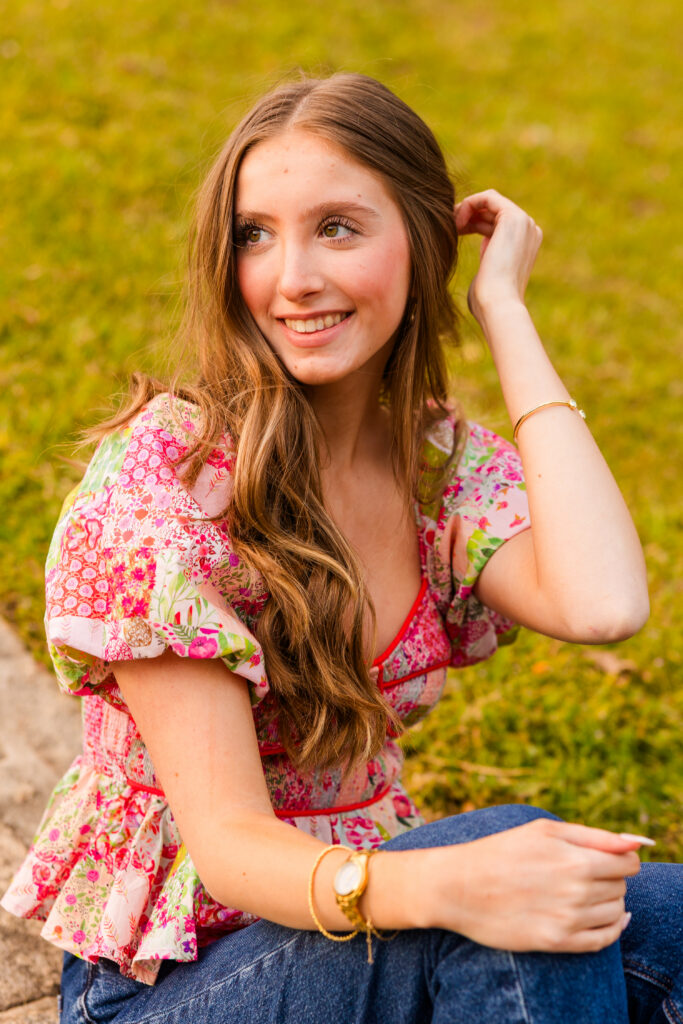Senior sitting on wall smiling naturally