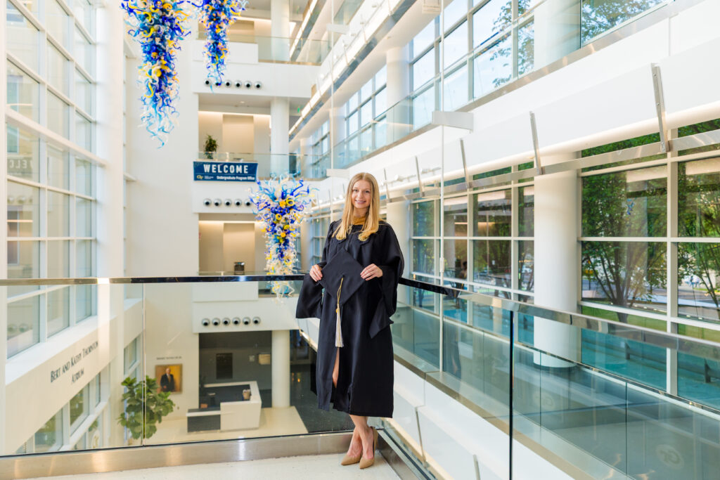 Wide graduation portrait inside the modern staircase at Scheller College of Business