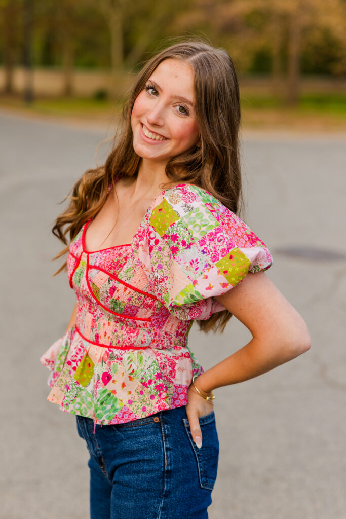 Senior posing from side with hands in pockets