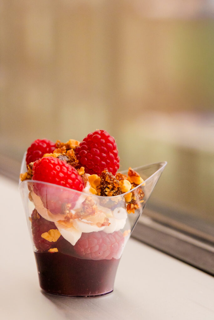 Close-up of individual dessert with cream and raspberries