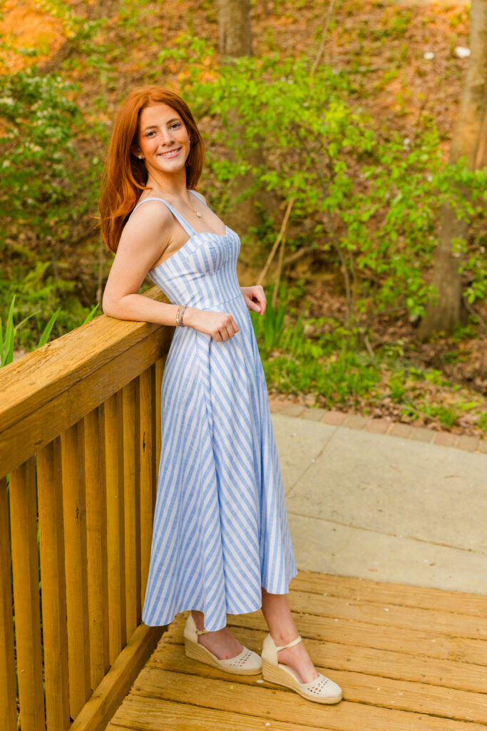 Senior girl leaning back against bridge rail ankles crossed