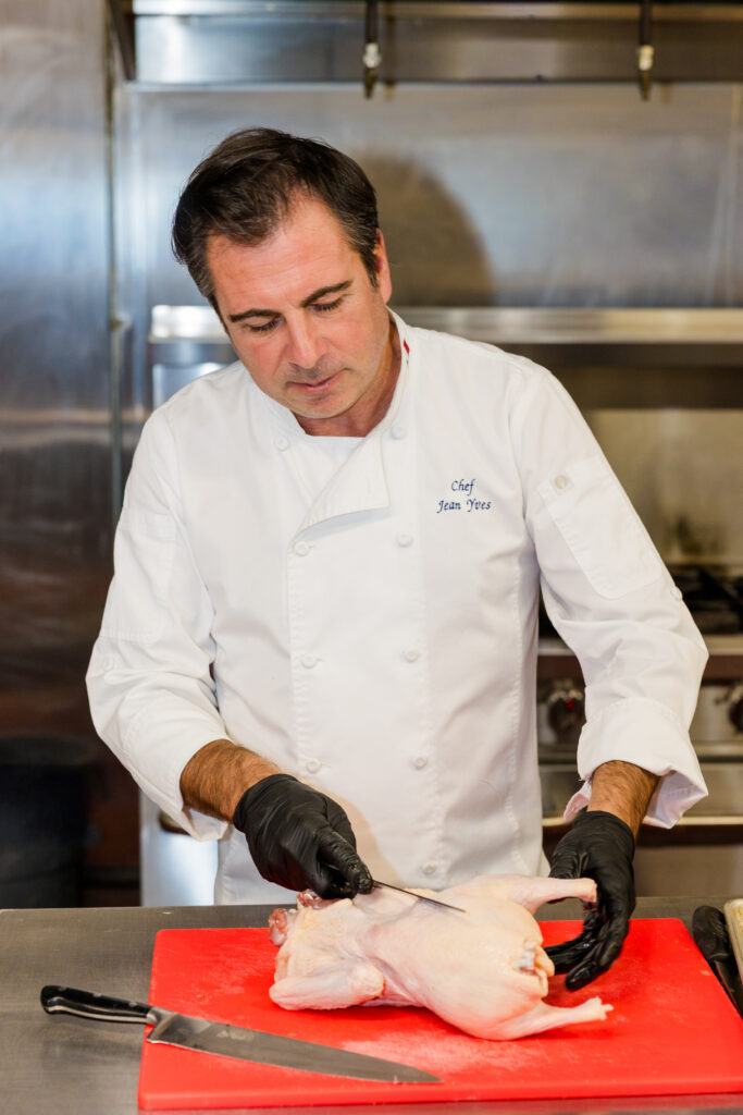 Chef preparing meat with knife during cooking process