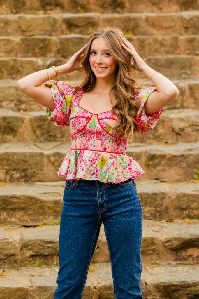 Talia hands on hair standing in jeans sassy pose