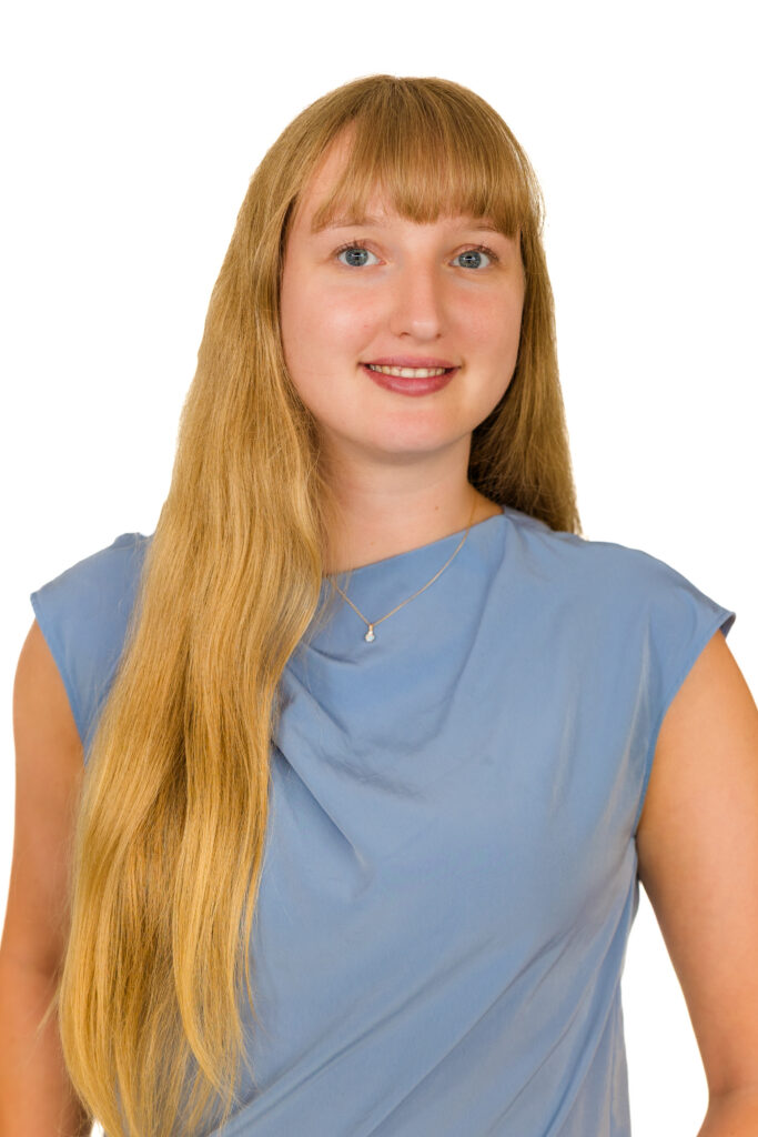 Professional headshot of blonde woman in light blue top facing camera, white backdrop, Atlanta photographer Laure Photography.